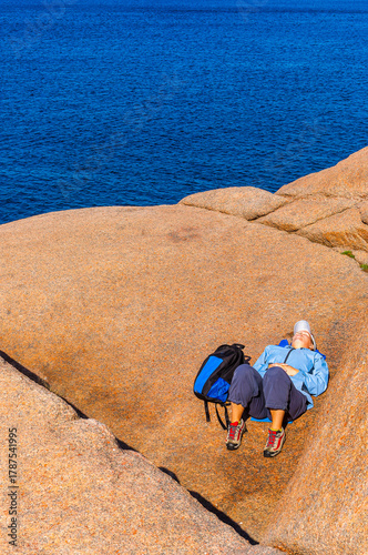 Female enjoys a moment of relaxation on a rocky coast in Bohuslän, Sweden, surrounded by natural beauty