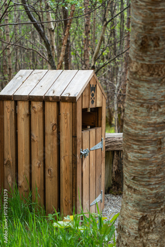 Rustic wooden litter bin in forest
