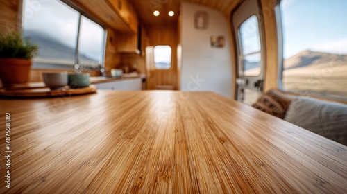 Cozy interior of a camper van with a wooden table and mountain view.