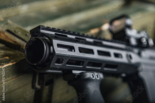 detailed firearm features, showcasing textured aluminum handguard with mlok slots and rugged finish