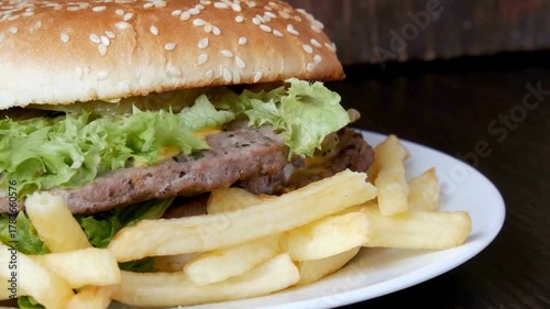 appetizing burger sandwich is rotating on the black background with copy space.