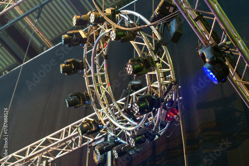 Industrial stage lighting mounted on aluminum frames inside the venue, prepared to illuminate the live performance area