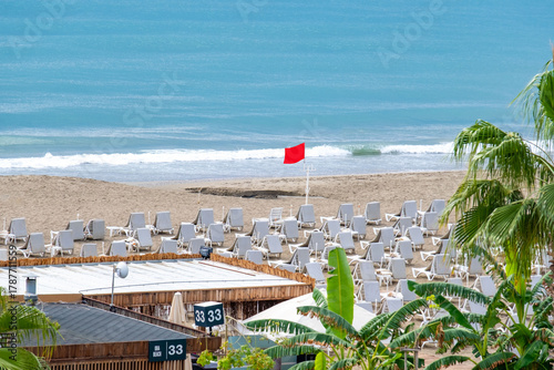 Fototapeta Naklejka Na Ścianę i Meble -  Beach promenade with palms, tropical beach scenes, historic peninsula Alanya, seaside view palm trees, colorful sunbeds and umbrellas, resort Turkey locations, calm ocean waves and tranquil sky