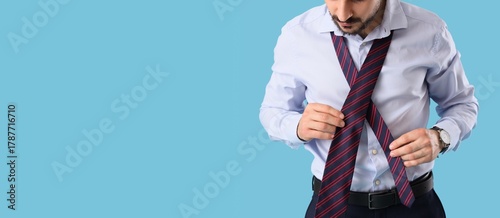 Young businessman tying nec...