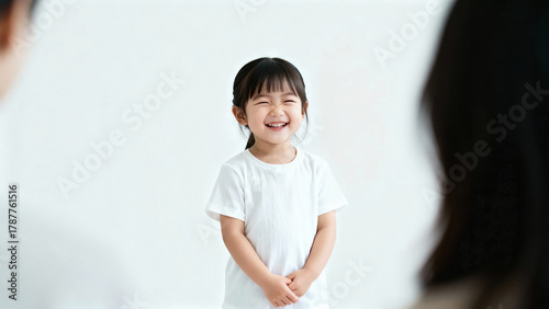 Portrait of a cheerful laughing Asian girl 3-4 years old in a white T-shirt
