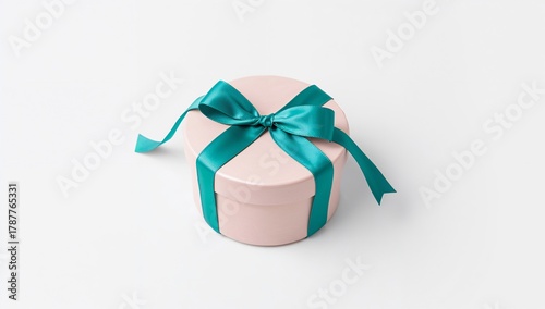 Pastel pink round gift box with vibrant teal ribbon bow isolated.