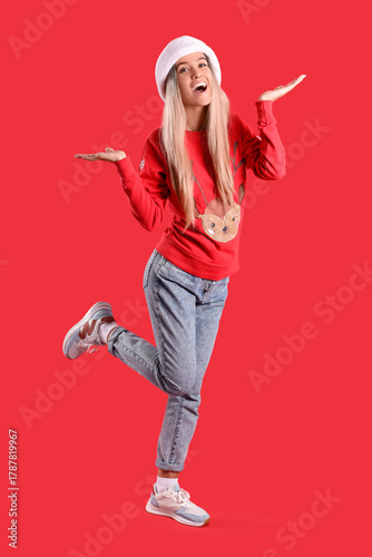Young woman in Santa hat an...