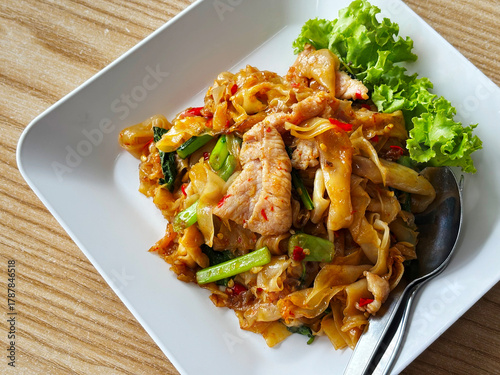 Close up Pad Kee Mao or Drunken Noodles, the Spicy stir-fried flat noodles with pork or chicken and spicy herbs, Thai food meal.