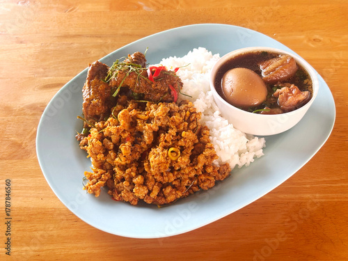 Thai-style meal featuring various traditional dishes served over rice