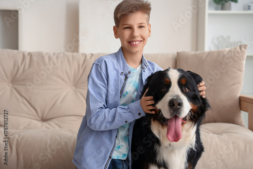 Boy and cute fluffy dog near sofa in living room