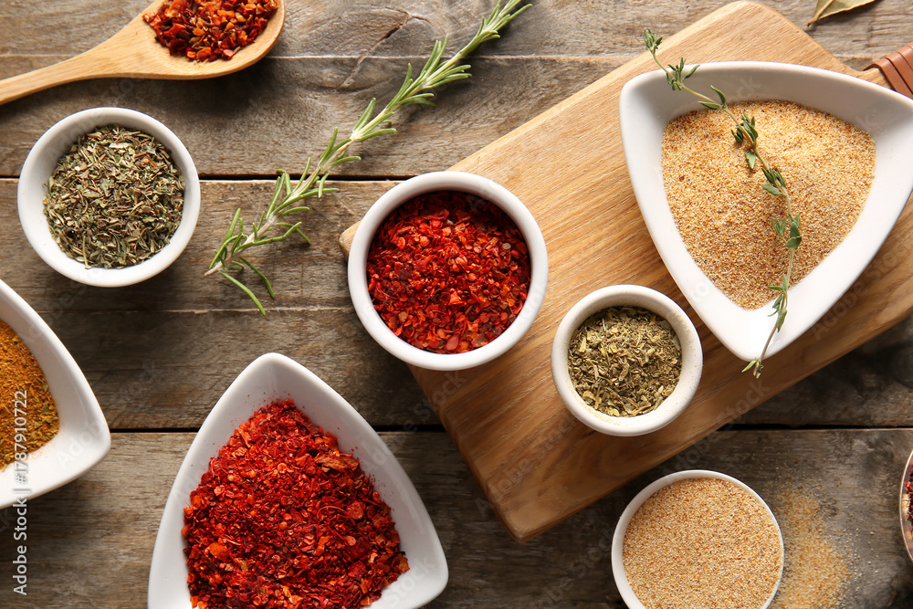 Fototapeta premium Composition with bowls of different aromatic spices on wooden background