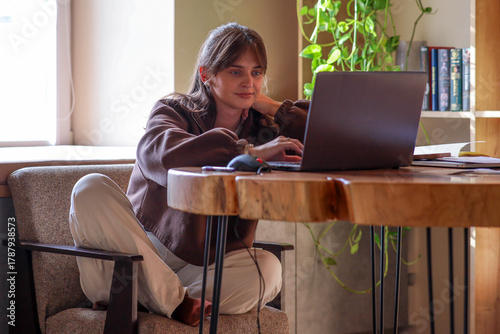 a young girl is working on a laptop, a homely cozy atmosphere