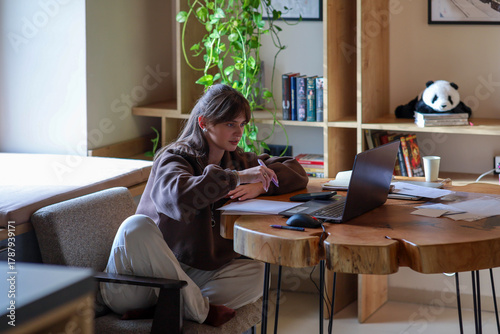 a young girl is working on a laptop, a homely cozy atmosphere