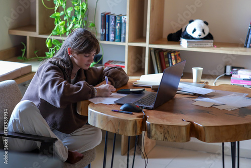 a young girl is working on a laptop, a homely cozy atmosphere