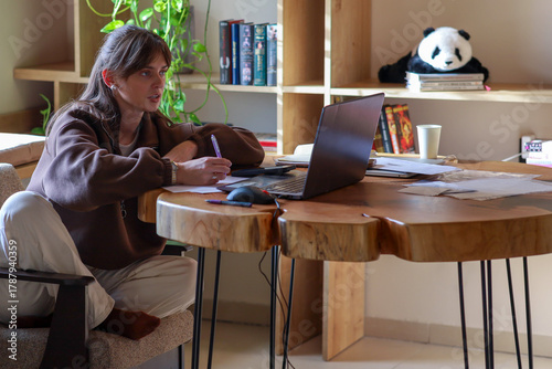 a young girl is working on a laptop, a homely cozy atmosphere