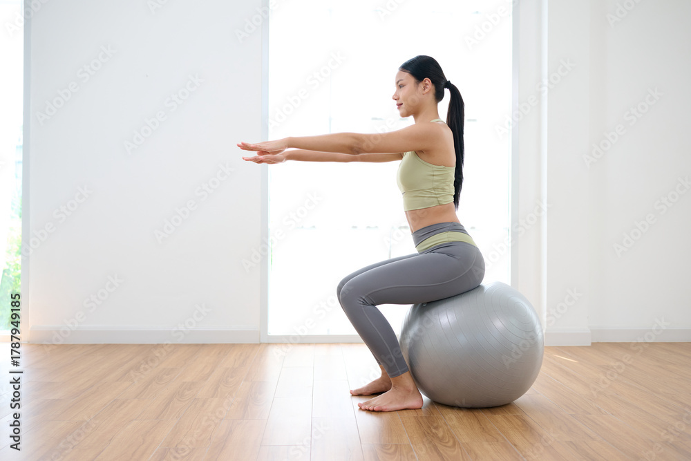 Fototapeta premium Woman sitting and doing fitness ball workout
