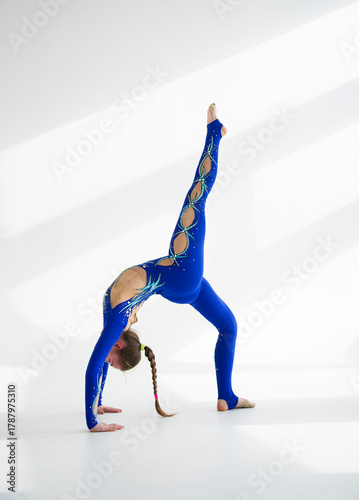 young woman in blue acrobatic suit doing yoga exercise.  Sport  conception