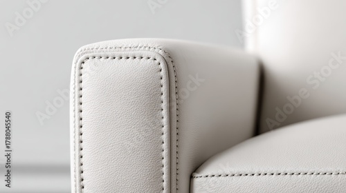 Close up of off white leather armrest with neat dark stitching highlighting smooth texture, clean seams and refined craftsmanship in modern sofa upholstery, elegant and durable
