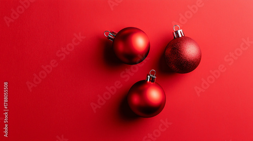três bolas vermelhas de natal sob fundo vermelho minimalista, decoração clássica e elegante, ideal para campanhas sazonais, posts festivos e materiais de varejo