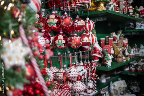 Abundant display of red and white Christmas ornaments and merchandise in a store or holiday market. Focus on gingerbread man baubles, capturing the festive shopping experience.