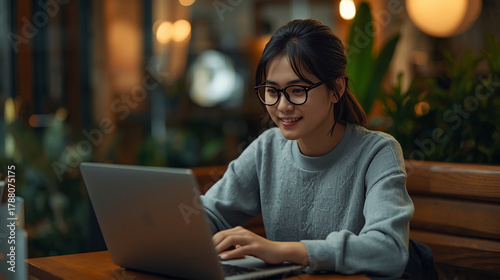 Young woman using cafe's internet to do her homework