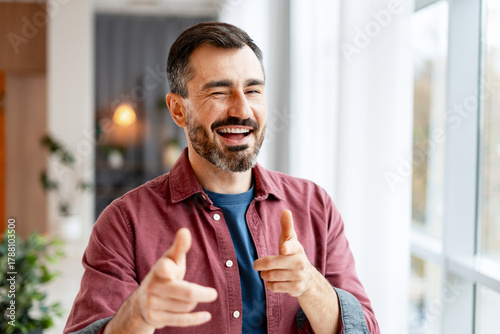 Φωτογραφία Mature man winking and pointing at camera