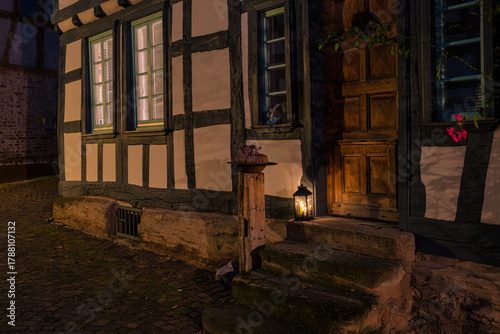 Fototapeta Naklejka Na Ścianę i Meble -  A small, romantic alley in the old town of Idstein in the Taunus region of Hesse, illuminated by streetlights in the evening.