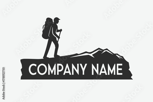 Silhouette hiker with backpack and walking stick climbs rocky mountain with company name displayed