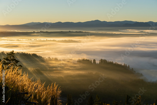 A wonderful autumn spectacle performed by the rays of the sun and the mists in the morning with the mountains in the background.