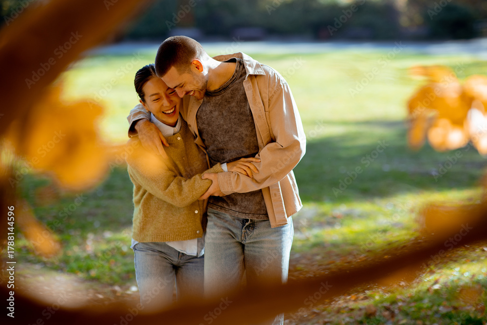 Naklejka premium Happy couple enjoying a sunny day in the park during autumn season
