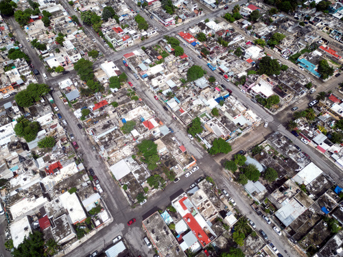 Aerial top-down view high altitude of slum a heavily populated urban informal settlement characterized by substandard housing and squalor poor living conditions streets and rusty metal home roof tops