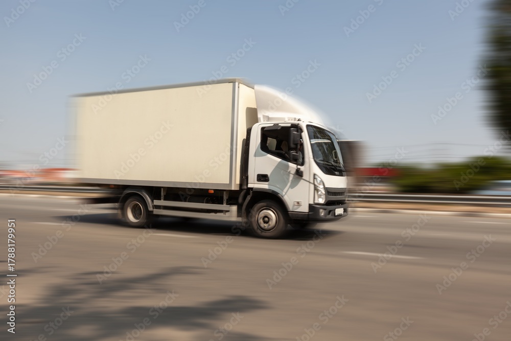 Fototapeta premium Car driving on road at high speed with moving background.