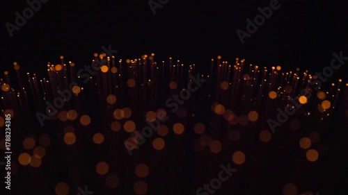 Fiber optic cables glowing in various colors on black background