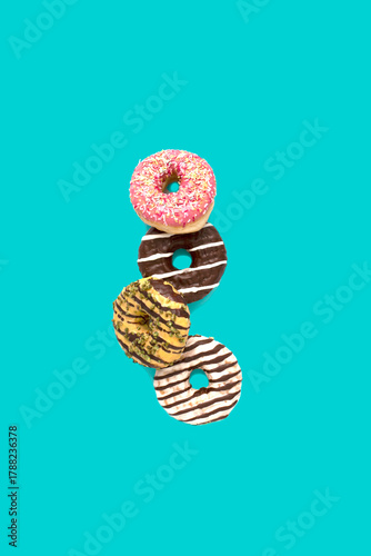 Donuts with colorful glaze flying on a pastel blue background