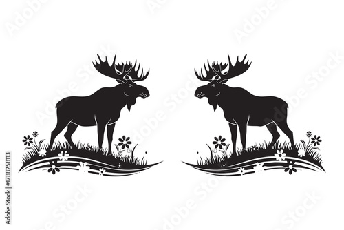 Two black silhouette moose with large antlers standing in grass with small flowers animal wildlife