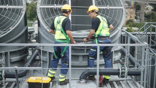 Engineers inspecting HVAC cooling systems on rooftop