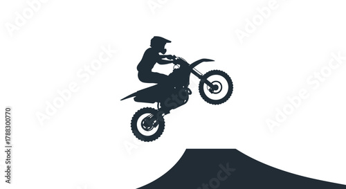 A motorcyclist does a wheelie off a ramp silhouette against a white background