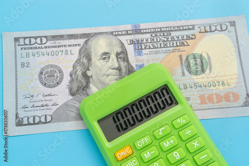 Business concept with dollar banknote and calculator on light blue background