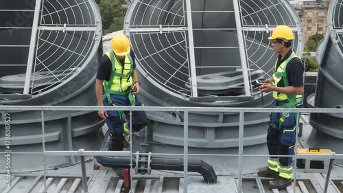 Engineers inspecting HVAC cooling systems on rooftop