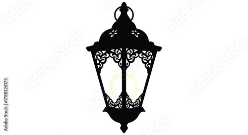 Elegant black silhouette of an ornate vintage street lamp with a glowing light
