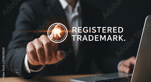 A businessman in a suit points at a glowing registered trademark symbol with 