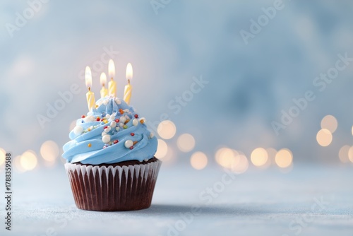 Delightful Blue Frosted Cupcake With a Candle and Festive Background Lights f...