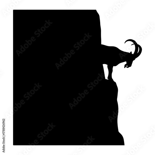 Black silhouette of an ibex on a rocky cliff edge goat