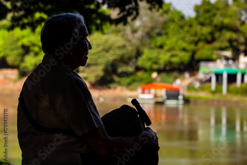Senior woman at the Ronda del Sinu walking path along the river bank in the city of Montería, Colombia.