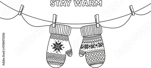 Two winter mittens hanging on a clothesline with the words stay warm above them