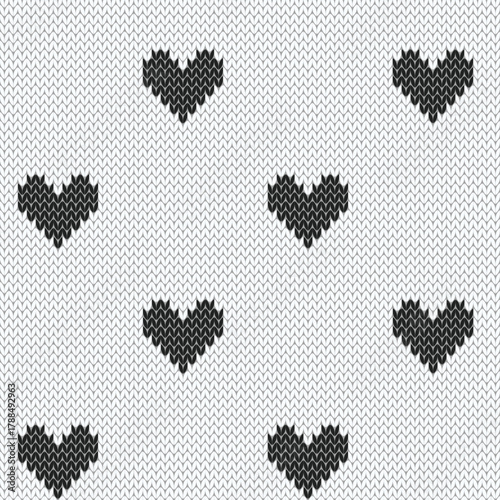Dotted black hearts on white background. Knitted seamless pattern. Vector illustration.