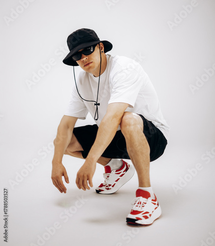 Young hip-hop dancer in street style summer outfit isolated on light background
