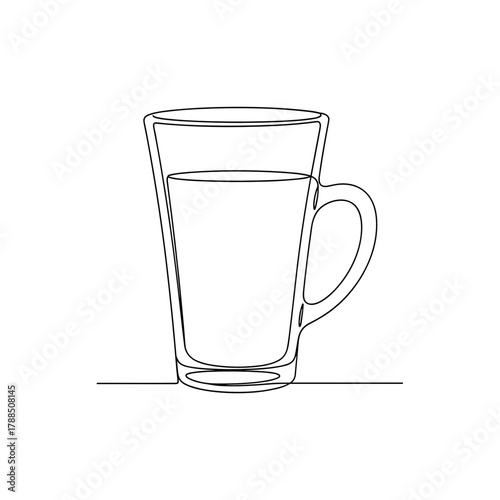 Clear latte glass filled with beverage on a simple surface  
