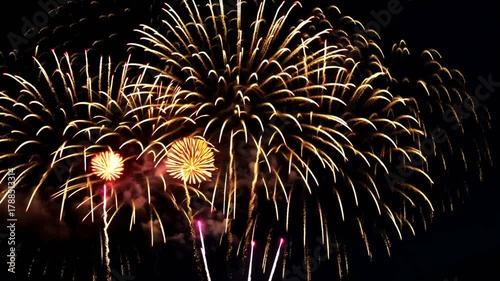 Spectacular burst of gold and red fireworks against a black night sky background