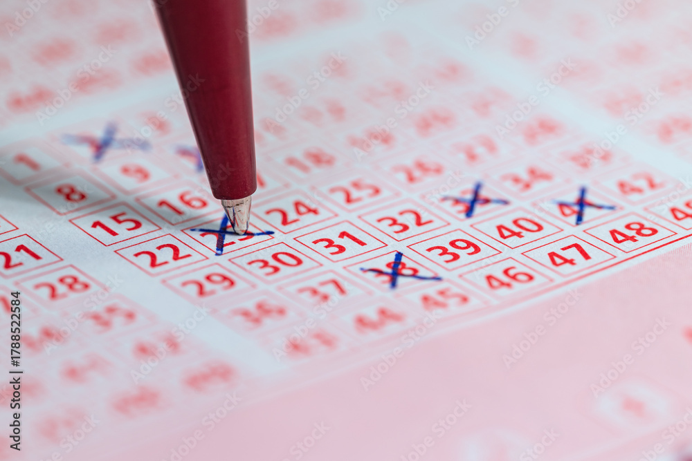 Fototapeta premium Lottoschein mit angekreuzten Zahlen und Kugelschreiber